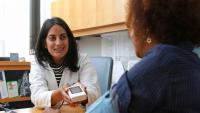 Cardiologist instructs hypertension patient in taking blood pressure